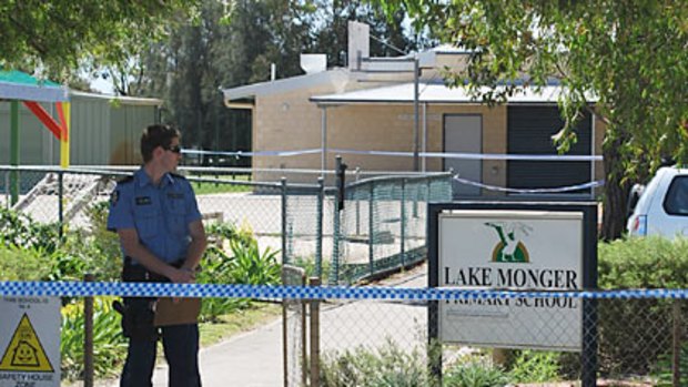 A police officer stands guard outside Lake Monger Primary School.