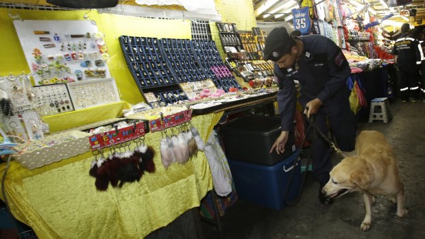 A Thai policeman patrols with a bomb-sniffing dog at a night market in Bangkok last month.