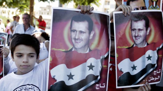 Lebanese boys hold portraits of Syrian President Bashar al-Assad, during a demonstration against a possible military strike in Syria, in front of the United Nations headquarters, in Beirut, Lebanon, on Sunday.