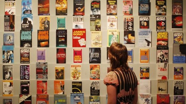Spy who loves them ... a woman peruses a collection of original Bond novels at the <i>For Your Eyes Only</i> exhibition in London.