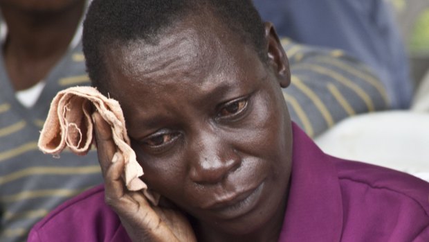 A woman wipes away tears after she viewed the body of a loved one killed during Thursday's attack.