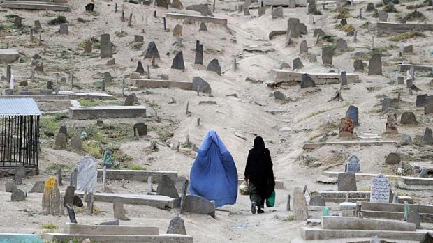 Afghan women walk through a graveyard in the old section of Kabul. Despite massive injections of foreign aid since the fall of the Taliban in 2001, Afghanistan remains desperately poor with some of the lowest living standards in the world.
