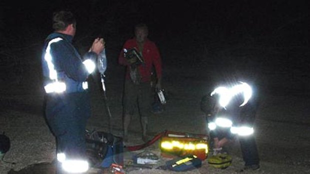 Helicopter crash ... a passenger lies buried in the sand as emergency services come to his rescue.