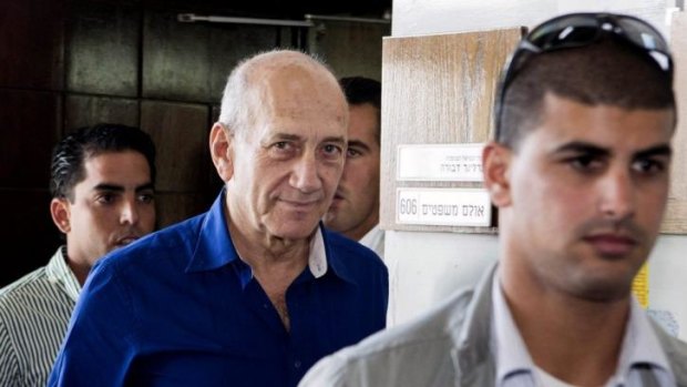 Ehud Olmert, left, leaves the Tel Aviv District Court on Tuesday after being sentenced to jail over his role in a bribery case.