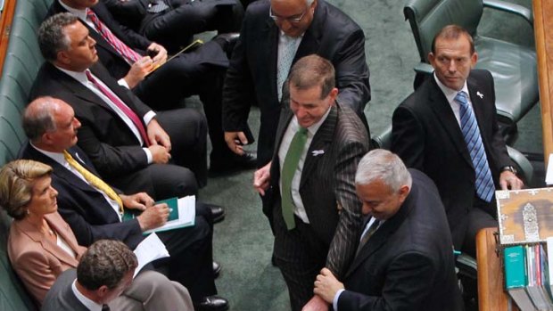Not amused ... Tony Abbott, right, and his opposition colleagues look on stonily as Peter Slipper makes the traditional show of reluctance while being taken to the speaker’s chair.