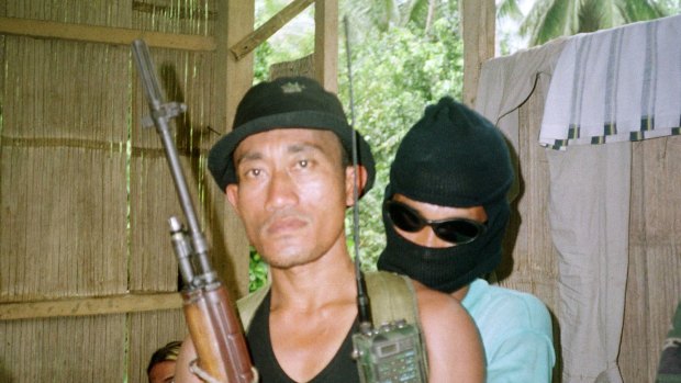 Armed Abu Sayyaf rebels guard a group of 21 hostages, including 10 foreigners in a hut at a secret location on this southern Philippine island of Jolo as seen in this April 29, 2000 file photo.  