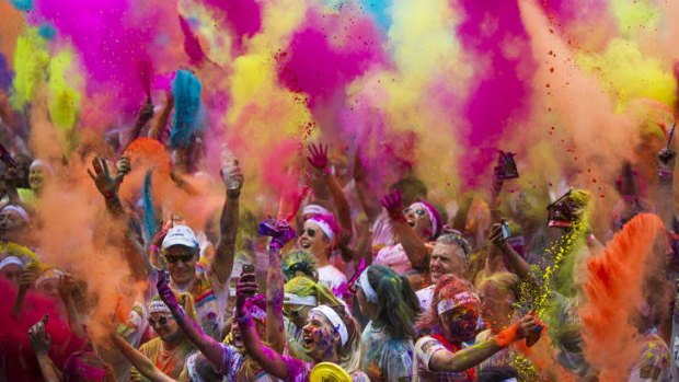 Crowds throw packets of coloured cornstarch during the celebrations at the Color Run at Commonwealth Park.