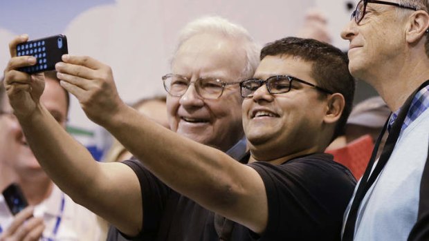 A shareholder takes a selfie with Warren Buffett, left, and Bill Gates.