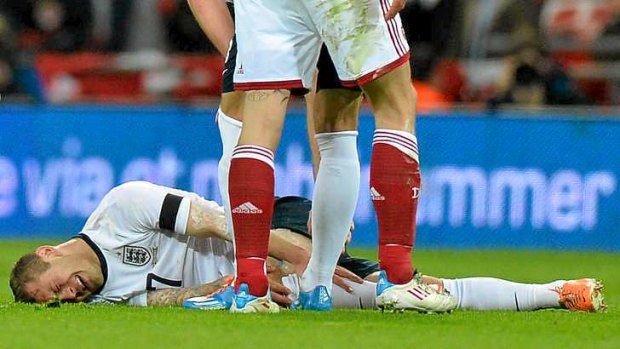 Second best: England midfielder Jack Wilshere lies on the ground after taking a knock in a challenge with Denmark defender Daniel Agger.
