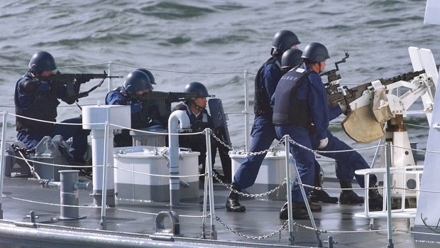 Members of Japan's Maritime Safety Agency aim their guns during an exercise against smugglers.