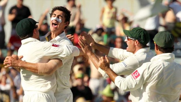 On a roll ... Mitchel Starc is congratulated by teammates after taking the prize wicket of Sachin Tendulkar.