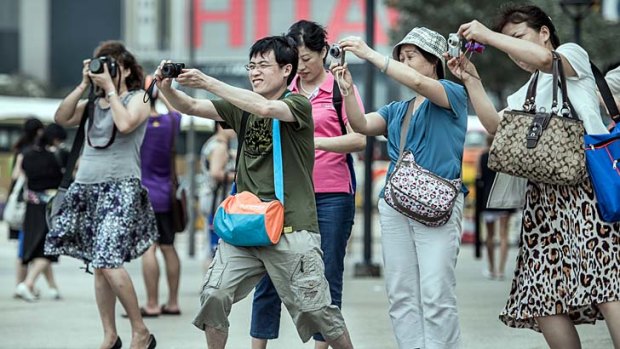 Mainland Chinese tourists take pictures during a visit to Hong Kong.