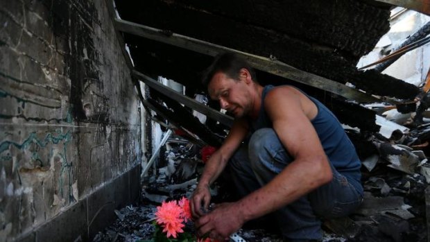 Dimitriy Gorozhaninov sits inside the remains of his family's home where his father, mother, sister and wife died after a shell landed on their home in Petrovskiy on the outskirts of Donetsk. 