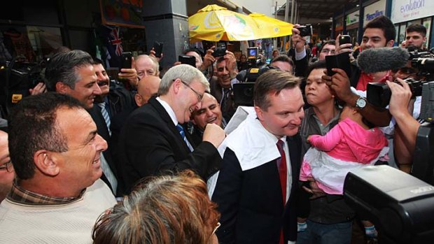 Hero worship: Kevin Rudd signs autographs for his followers in Fairfield in western Sydney this week using Chris Bowen's back.