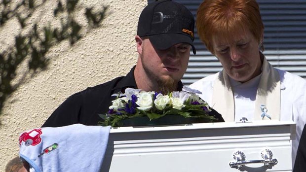A man carries the casket of five-month-old Baxtor Gowland.
