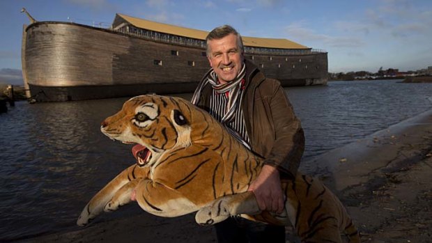 Johan Huibers poses with a stuffed tiger in front of the full scale replica of Noah's Ark.