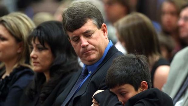 Shooting victim ... Dallas Green, seated next to his parents Roxanna and John Green, wipes a tear away  during his sister's funeral.