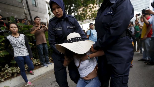 Police seize a demonstrator in Kuala Lumpur.