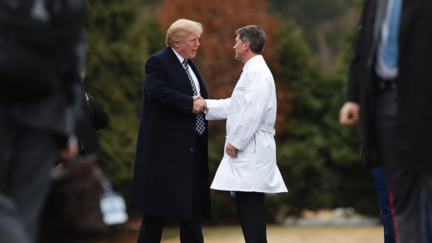 President Donald Trump shakes hands with White House physician Dr Ronny Jackson as he boards Marine One as he leaves Walter Reed National Military Medical Centre in Bethesda, Maryland, after his first medical check-up as president. 