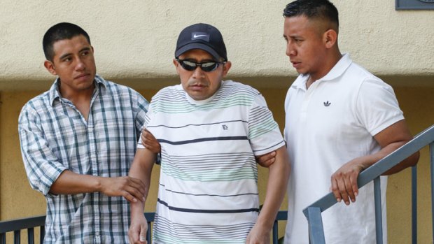 Antonio Lopez Chaj, centre, is assisted to walk down the stairs by his nephew Eric Chaj, left, and his brother Pedro Chaj, right, to appear at a news conference in Los Angeles.