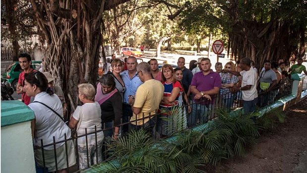 Passport applicants ... Cubans queue outside a Migration Office.