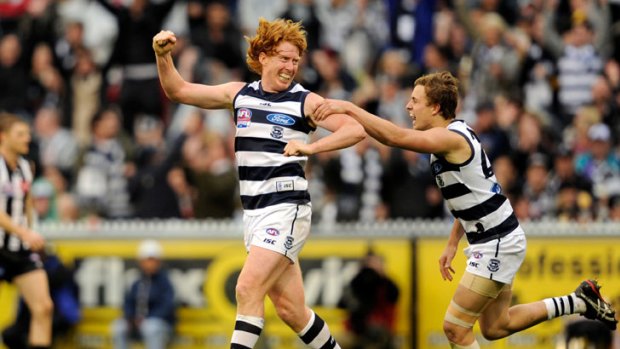 Geelong captain Cameron Ling and Mitch Duncan celebrate a goal against Collingwood in the grand final.