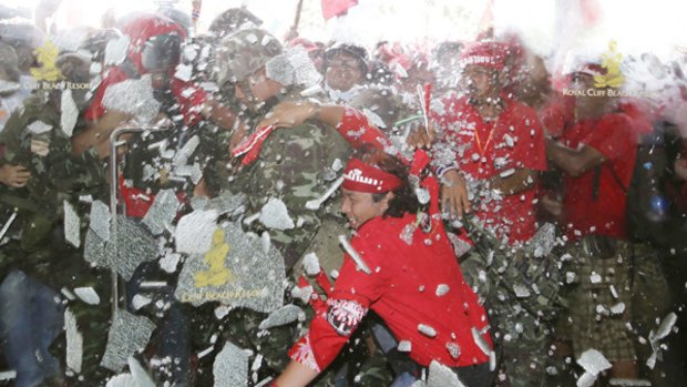 Red-shirted supporters of ousted Thai prime minister Thaksin Shinawatra smash their way into a hotel where the ASEAN summit was to be held.