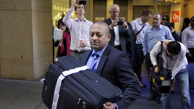 Evidence ... Detective Sergeant Ronald Prasad removes a suitcase Michael Williamson had used from the Sydney offices of the Health Services Union yesterday.