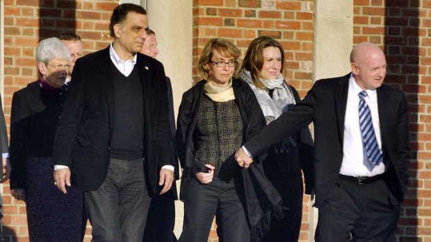 Anti-gun group ... Gabrielle Giffords (centre) holds hands with her husband Mark Kelly as they leave a meeting in Connecticut.