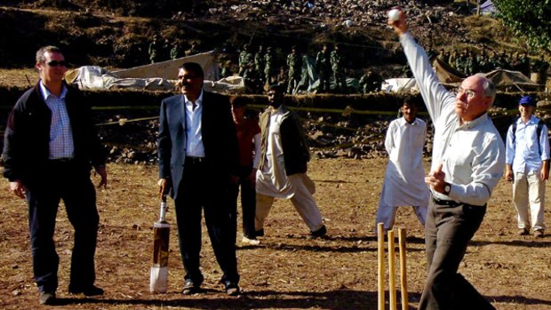 Over the wicket ... then PM John Howard sends down a ball during a hit-out at ''Camp Bradman'', an Australian Army medical camp in earthquake-hit northern Pakistan in 2005.
