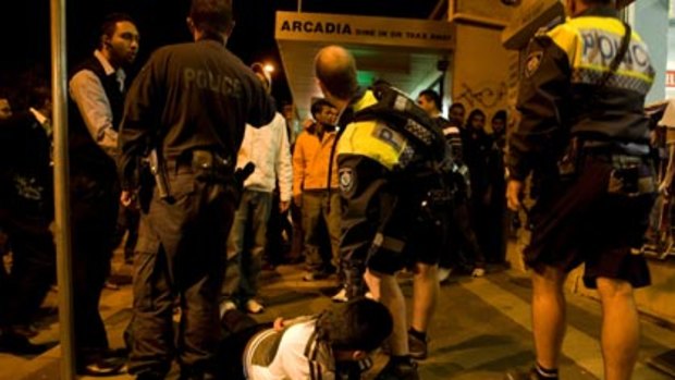 High profile ... police apprehend a man as tension boil over in Harris Park last night.
