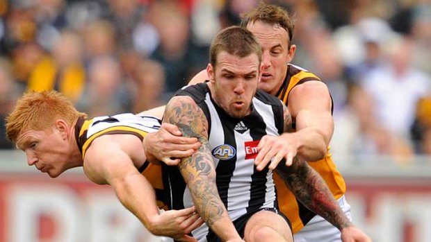 Collingwood's Dane Swan gets his kick away despite pressure from Hawthorn's Kyle Cheney (left) and David Hale at the MCG.