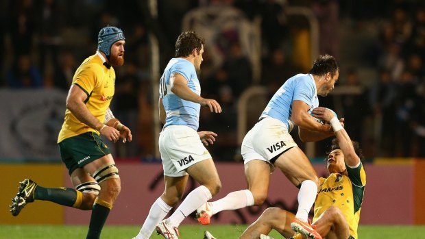 Down and out: Matt Toomua, right, cops a heavy bump during the Wallabies' match against Argentina.