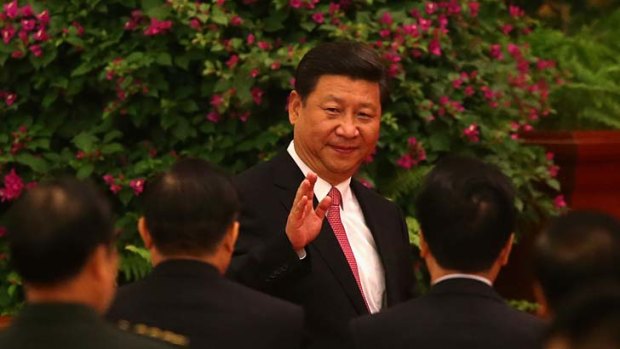 Chinese President Xi Jinping waves to guests as he arrive for a dinner marking the 64th anniversary of the founding of the People's Republic of China.