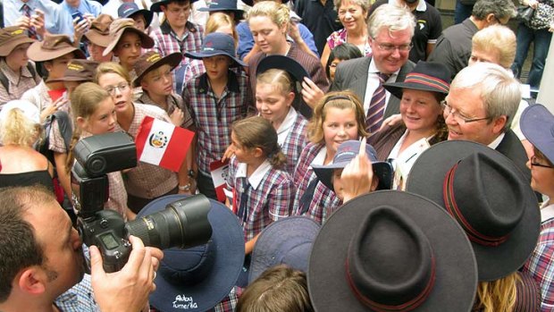 Kevin Rudd is mobbed by a throng of schoolchildren during the launch of Caritas charity fundraiser Project Compassion.