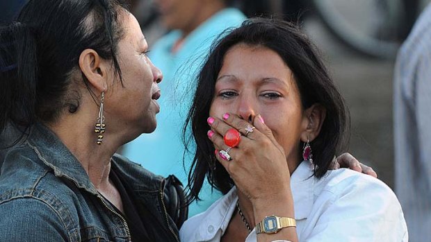 Hundreds dead ... a woman weeps outside the prison.