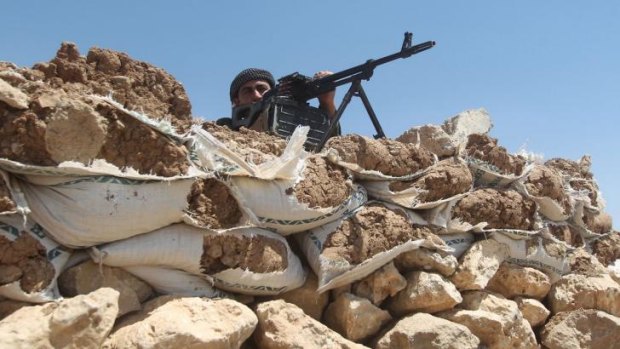 Holding the line ... Iraqi Kurdish Peshmerga fighters take position as they monitor the area from their front line position in Bashiqa, a town 13 kilometres north-east of Mosul.