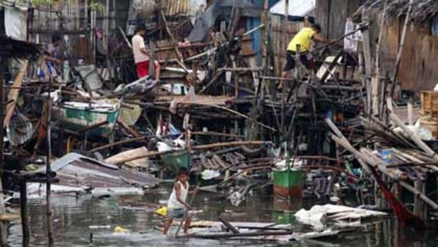 People recover belongings from their destroyed shanty homes in Las Pinas, south of Manila.