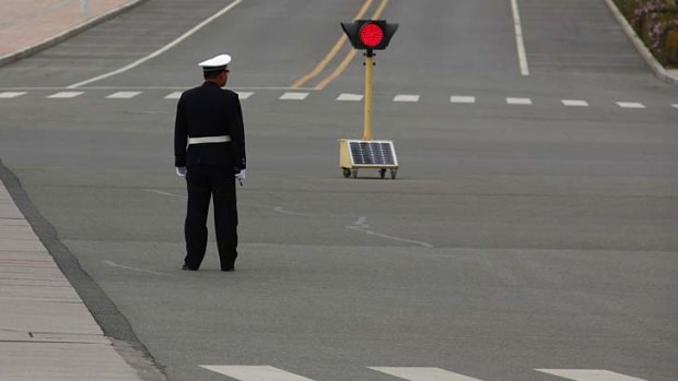A policeman monitors an empty intersection.