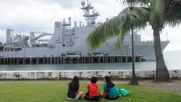 Students look towards the USS Germantown and USS Peleliu (unseen) in the northern Philippine port city of Olongapo.