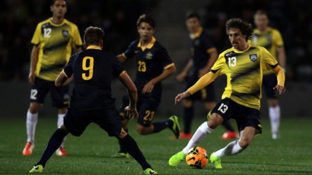 On the charge: All Stars player Albert Riera has a cut at the Young Socceroos defence.