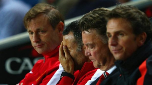 Stuck in the middle: Assistant manager Ryan Giggs and manager Louis van Gaal feel the strain in the dugout.