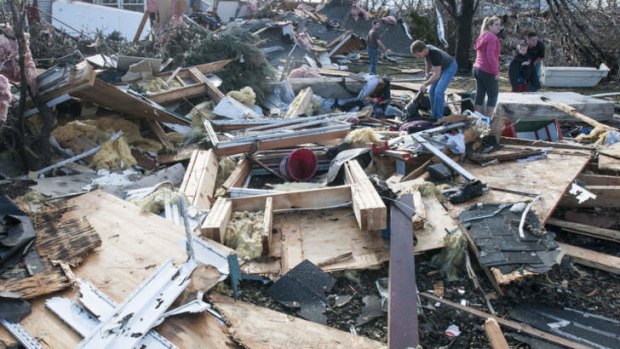 Residents search through debris following the likely tornado touch down in Gifford, Illinois.