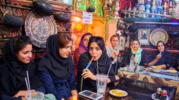 Smoking a water pipe at a teahouse in Iran.