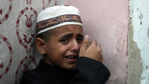 Grief ... Ahmed, the son of Hisham Saidani, weeps at his father's funeral in the Al-Bureij refugee camp.