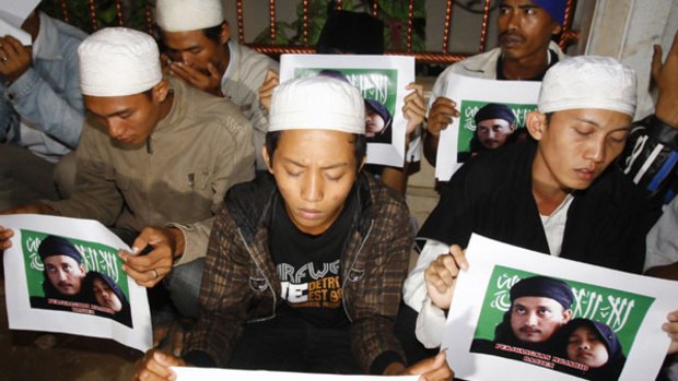 Supporters of Bali bomber Imam Samudra mourn holding pictures of Samudra and his daughter during a prayer in Serang, Banten province.