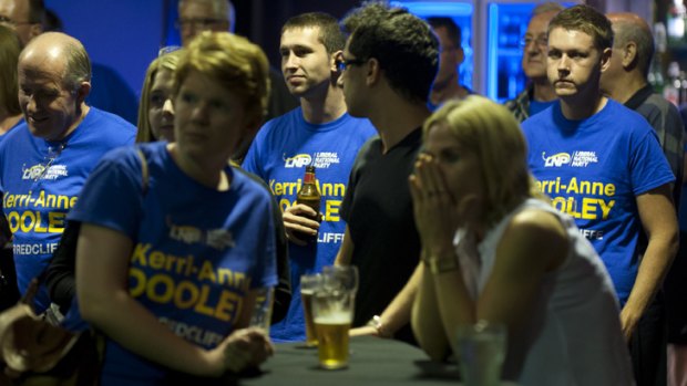 Party faithful watch a television report at the post election function for LNP candidate Kerri-anne Dooley in the Recliffe byelection.