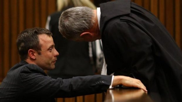 Distressed ... Oscar Pistorius cries as he talks to his attorney Barry Roux, right, after listening to evidence during his trial in Pretoria.