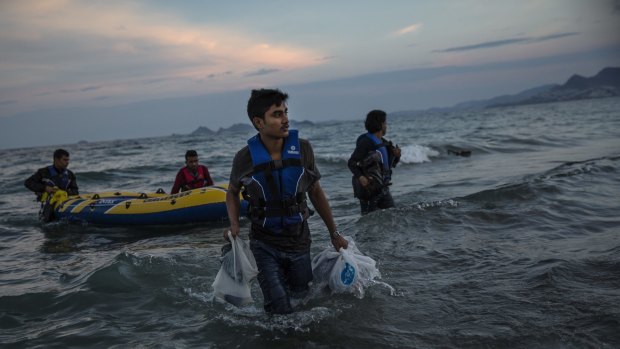 Pakistani migrants arrive on the beach in Kos, Greece, at dawn after making their way from Turkey