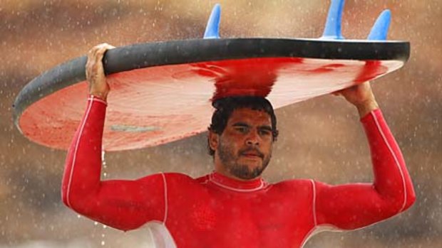 Greg Inglis carries his surfboard during a Melbourne Storm training session at Anglesea Beach earlier this year.